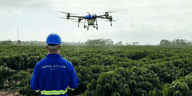 Operador Agro Atlas voando drone sobre o campo